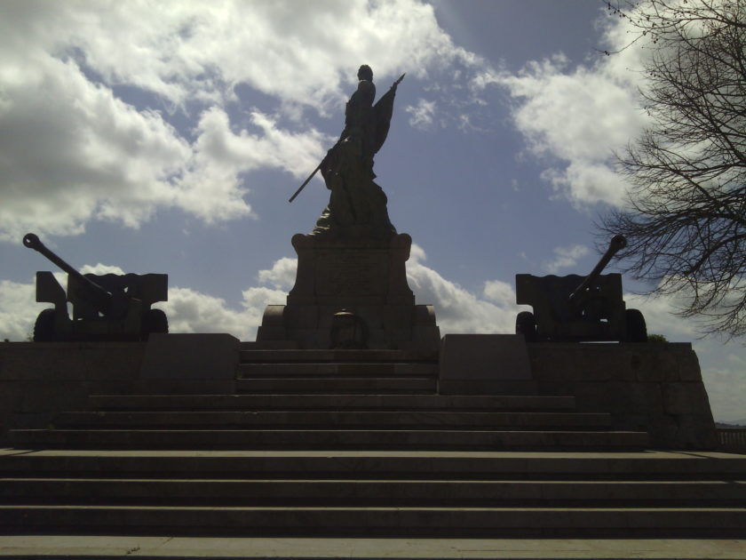 Monumento ai Caduti della prima guerra mondiale. Il monumento è composto da un basamento a tronco di piramide a base quadrata, con gradinata sulla parte anteriore, e da una statua che rappresenta la Patria riconoscente, che cinge l’elmetto fregiato di lauro e quercia. In una mano regge il libro della Storia e la palma della pace vittoriosa e con l’altra indica alla gente il sacrificio delle vittime. Sotto c’è un eroe che stringe al petto il Tricolore. Ai lati della base della statua ci sono due cannoni e, tra essi, una corona d’alloro in bronzo. Data di collocazione: 16/12/1922